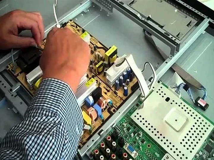 Technician checking an LCD TV at a customer's home